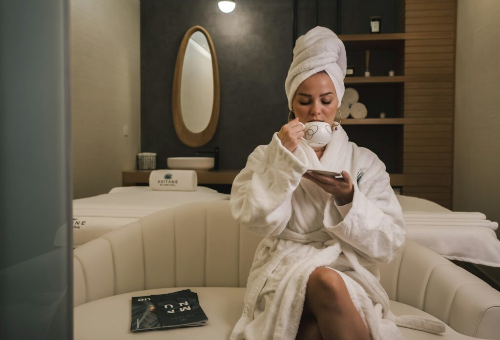 Donna in accappatoio che si concede una tazza di tè in una cabina spa